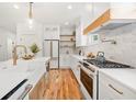 Modern kitchen boasts white cabinets, marble backsplash, brass accents, and stainless appliances at 224 Cambridge Avenue, Decatur, GA 30030