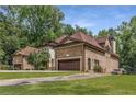 Brick home showcasing architectural detail, a three car garage, and lush landscaping at 450 Dorset Sw Way, Smyrna, GA 30082