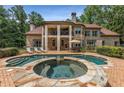 Resort style pool area with spa, stone patio, and covered veranda at 450 Dorset Sw Way, Smyrna, GA 30082