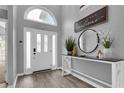 Inviting foyer features wood flooring, a stylish console table, and a striking arched window above the entrance at 3568 Foxworth Ct, Buford, GA 30519