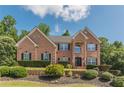 Charming brick home with well-maintained landscaping, lush bushes, and manicured lawn at 3202 Lucky Pl, Conyers, GA 30013