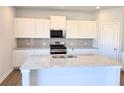 Bright kitchen features granite countertops, stainless appliances, and ample cabinet space at 2539 Brown Dove Way(Lot 81), Grayson, GA 30017