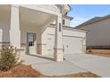 Inviting front porch with stone accents, leading to an attached two-car garage at 2519 Brown Dove Way (Lot 79), Grayson, GA 30017