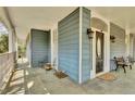 Inviting front porch, featuring classic columns, neutral tile flooring, and an arched front door at 561 Culberson Sw St, Atlanta, GA 30310