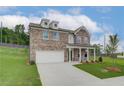 New two-story brick home with an attached two-car garage and a concrete driveway on a grass lot at 1797 Kingsmere Run Dr, Loganville, GA 30052