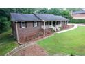 A brick home showcasing a well-kept lawn and landscape, complemented by the home's architectural details at 2202 Springdale Dr, Snellville, GA 30078