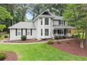 View of the exterior showcasing its manicured lawn and mature landscaping around the foundation at 1655 Oak Crest Ct, Marietta, GA 30066