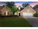 Charming brick home with manicured lawn and two-car garage at 1065 Beacon Hill Xing, Alpharetta, GA 30005