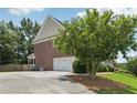 Exterior image showcasing the garage and driveway, enhanced by lush landscaping at 2444 Mossy Branch Dr, Snellville, GA 30078