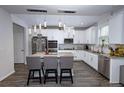 Bright kitchen features white cabinets, granite countertops, stainless steel appliances, and an island with seating at 3227 Hidden Valley Cir, Lawrenceville, GA 30044