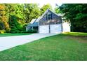 Exterior facade featuring stone accents, two-car garage, driveway, and lush, green lawn at 85 Lamar Ln, Covington, GA 30016