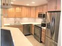 Well-lit kitchen featuring stainless steel appliances, light wood cabinets, and mosaic backsplash at 1130 Piedmont Ne Ave # 404, Atlanta, GA 30309