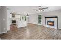 Open concept living space with a modern kitchen, cozy fireplace, and gleaming hardwood floors at 129 Fawn Trail Trl, Hiram, GA 30141