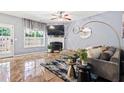 Cozy living room with a fireplace, plush seating, modern decor, and lots of natural light at 3832 Augustine Pl, Rex, GA 30273