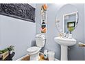 Stylish half bath featuring a pedestal sink, oval mirror, and contemporary decor at 3832 Augustine Pl, Rex, GA 30273