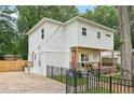 Side view of a modern home featuring a charming porch, well-maintained yard, and a secure black fence at 1266 Elizabeth Sw Ave, Atlanta, GA 30310