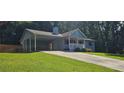 Light blue single-story home featuring a front porch, covered parking, and a manicured lawn at 2357 Whitehouse Rd, Dacula, GA 30019
