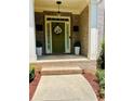 Inviting front entrance with a decorative wreath and olive green door and brick surround at 6398 Foggy Oak Dr, Fairburn, GA 30213