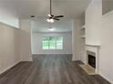 Bright living room with new vinyl floors, a fireplace, a fan and fresh paint at 1570 Jami Hollow Way, Lawrenceville, GA 30043