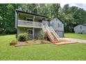 View of the exterior of a two-story home with a well-manicured lawn and a charming covered front porch at 174 Village Dr, Hiram, GA 30141
