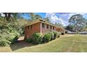 Side view of a brick single-story home with lush landscaping at 3377 Brookfield Ln, Decatur, GA 30032