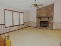 Cozy living room with a stone fireplace, three windows, carpet and vintage wall paper at 4187 Alaina Cir, Austell, GA 30106