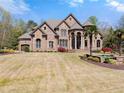 Elegant stone home with manicured lawn, water feature and palm trees at 1310 Settles Rd, Suwanee, GA 30024
