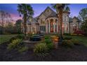 Stately stone home featuring manicured lawn and mature palms at 1310 Settles Rd, Suwanee, GA 30024