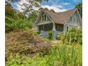 Lovely home with a screened-in porch surrounded by colorful flowers and lush greenery at 222 Winonna Dr, Decatur, GA 30030