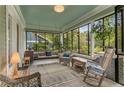 Relaxing screened porch with wicker furniture, a swing, and views of the surrounding greenery at 222 Winonna Dr, Decatur, GA 30030