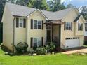 Charming two-story home with a light yellow exterior, brown shutters and a green lawn at 355 Tambec Nw Trce, Lilburn, GA 30047