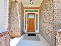 Inviting front entrance with brick facade, sidelights, and beautiful wooden door at 1264 Brynhill Ct, Buford, GA 30518
