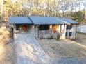 Charming single-story brick home featuring a long driveway, well-kept lawn, and mature trees at 4011 Lake Carlton Rd, Loganville, GA 30052