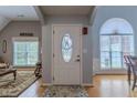 Elegant foyer featuring a decorative front door, natural light, and hardwood floors, creating a welcoming ambiance at 5176 Ashbury Manor Ln, Sugar Hill, GA 30518