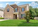 Charming two-story brick home with a manicured lawn and mature tree at 5430 Breckinridge Ln, Cumming, GA 30040