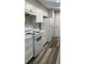 Modern kitchen featuring white cabinets, stainless steel appliances, and laminate flooring at 188 Rue Fontaine, Lithonia, GA 30038
