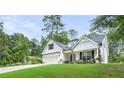 Inviting home boasts a lush lawn, white siding, and a charming covered porch with seating at 5015 Monticello Dr, Villa Rica, GA 30180