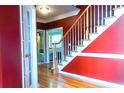 Foyer with hardwood floors, staircase, and stylish red accent wall at 555 Stoneglen Sw, Atlanta, GA 30331