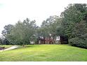 Expansive green lawn and mature trees surrounding the traditional brick home at 555 Stoneglen Sw, Atlanta, GA 30331