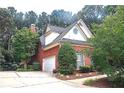 Side view of brick home with two-car garage and manicured landscaping at 555 Stoneglen Sw, Atlanta, GA 30331