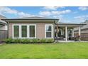 Home's back exterior showing the covered patio and well-maintained lawn at 205 Floral Valley Dr, Woodstock, GA 30188