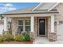 Inviting front porch with stone pillars and outdoor seating, perfect for relaxing at 205 Floral Valley Dr, Woodstock, GA 30188