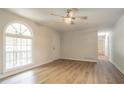 Spacious living room with light wood floors, large window, ceiling fan, and white walls at 356 Waterway Trl, Powder Springs, GA 30127