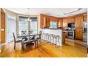 Eat-in kitchen area featuring stainless steel appliances, breakfast bar, hardwood floors and natural light at 485 Greyhawk Way, Fairburn, GA 30213