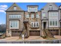 Elegant townhomes with stone and brick facades, attached garages, and landscaped yards at 3450 Commander Cv, Suwanee, GA 30024
