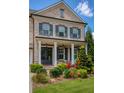 Charming front porch with classic columns, dark shutters, and vibrant landscaping, a welcoming exterior at 4430 Alister Park Dr, Cumming, GA 30040