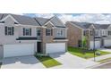 Inviting townhouse community with modern brick and gray exteriors, complete with attached garages and manicured lawns at 205 Silver Moon Dr, Loganville, GA 30052