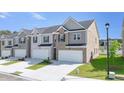 Attractive townhome complex with brick and siding exteriors, showcasing attached garages and landscaped front yards at 205 Silver Moon Dr, Loganville, GA 30052