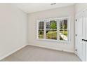 Bright bedroom showcasing a large window with scenic outdoor views and plush carpet at 1995 Deco Dr, Kennesaw, GA 30144
