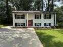 Lovely two-story home with white brick, black shutters, and a vibrant red front door at 2764 Ocean Valley Dr, Atlanta, GA 30349